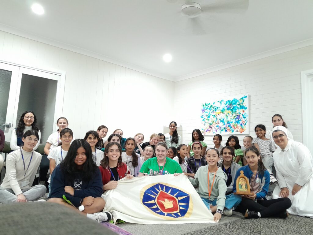 A Schoenstatt girls' and young women's group gathered with their banner