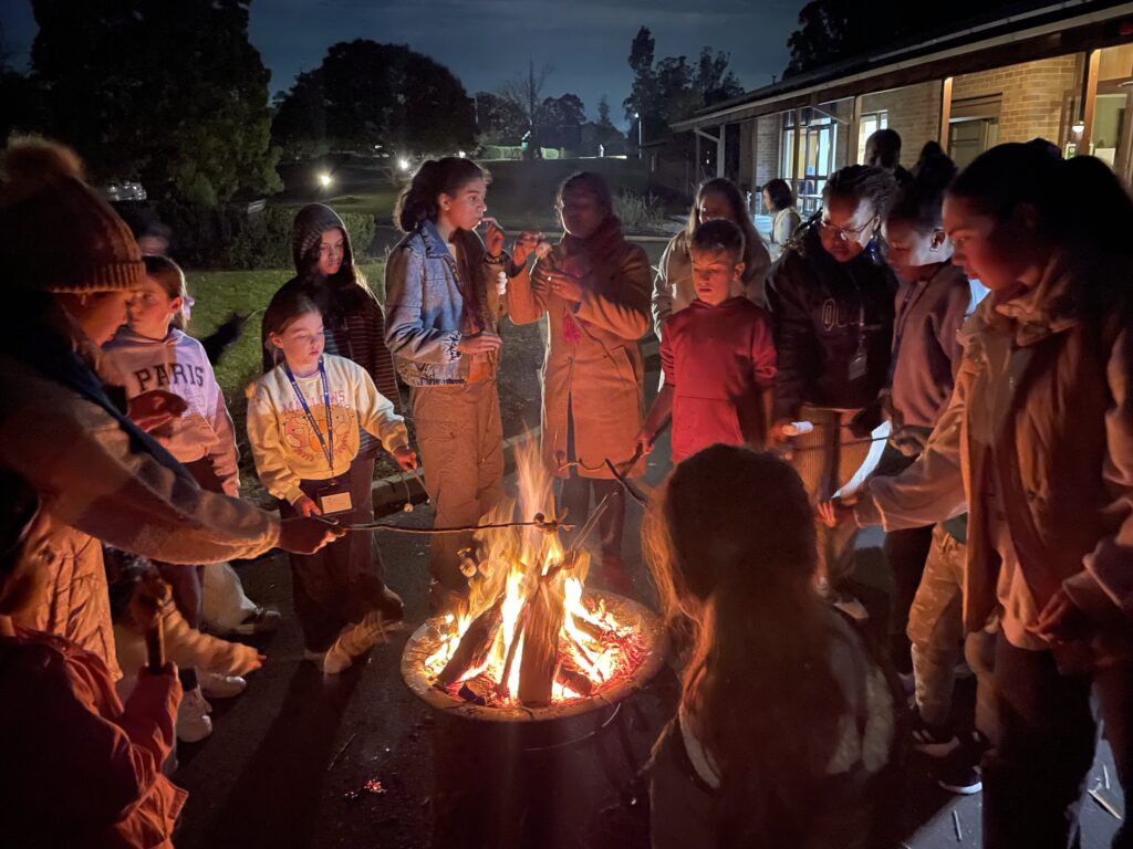 Schoenstatt families gathered around a fire pit in the evening